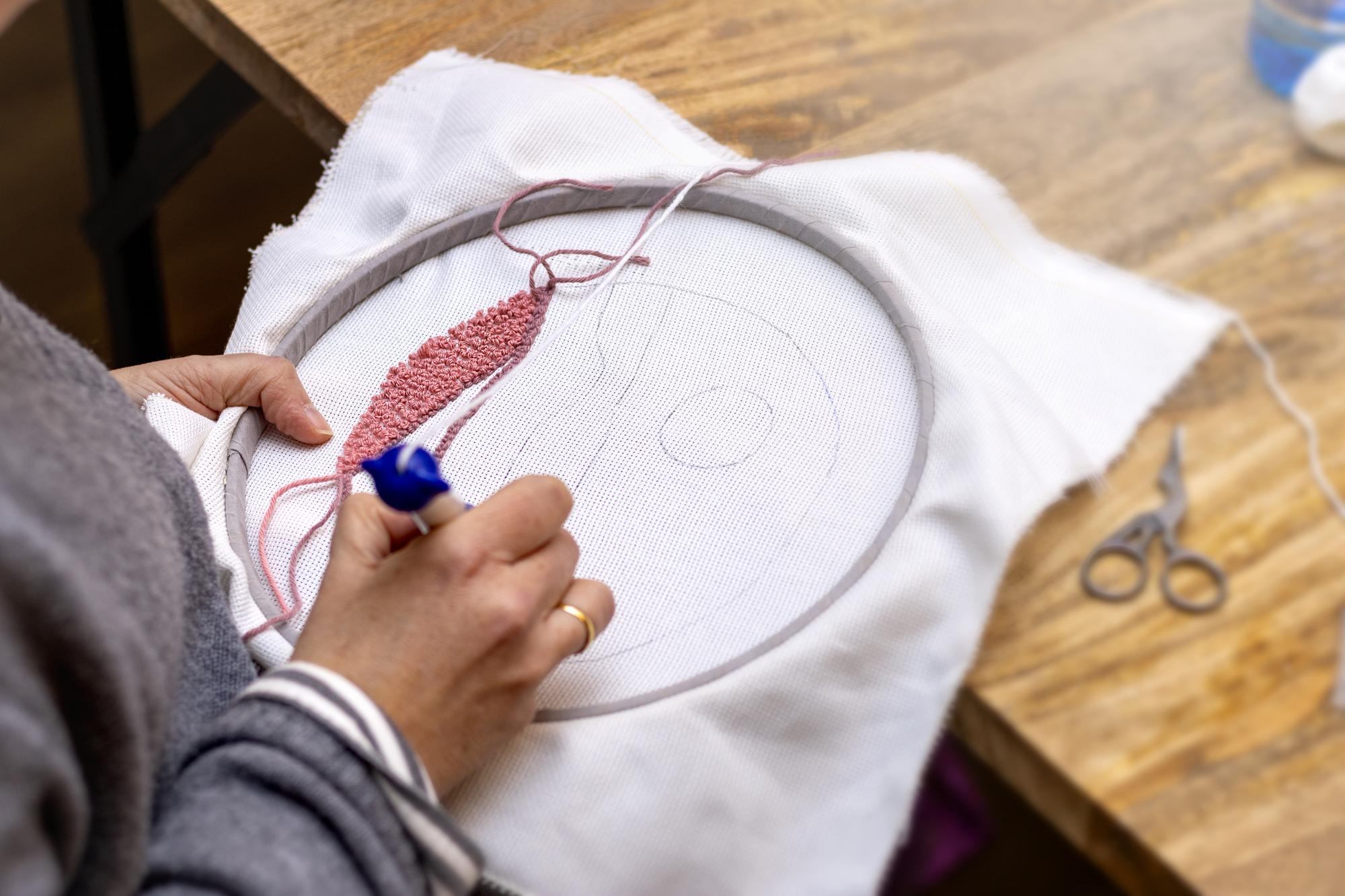 hands adjusting embroidery hoop